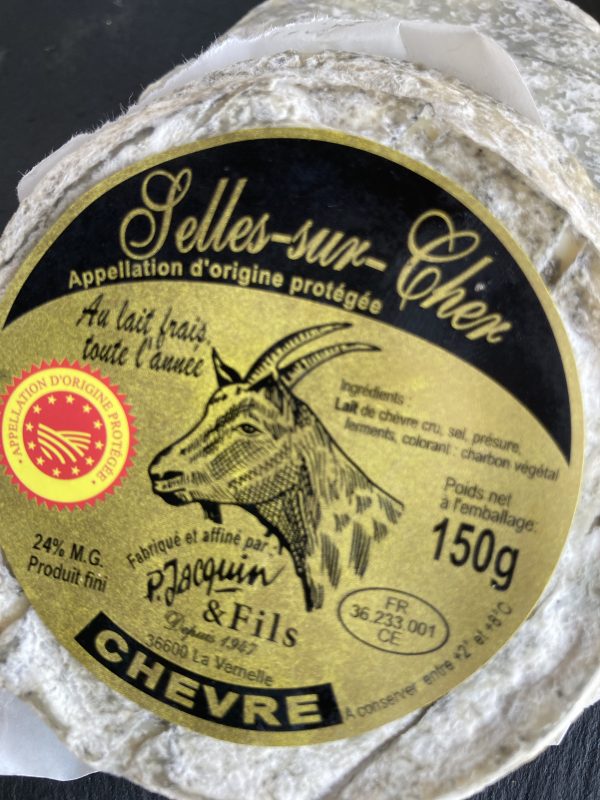 Round moulded cheese with a gold and black label and picture of a goat